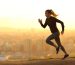 Side view full body portrait of a runner woman running in the outskirts of the city at sunset